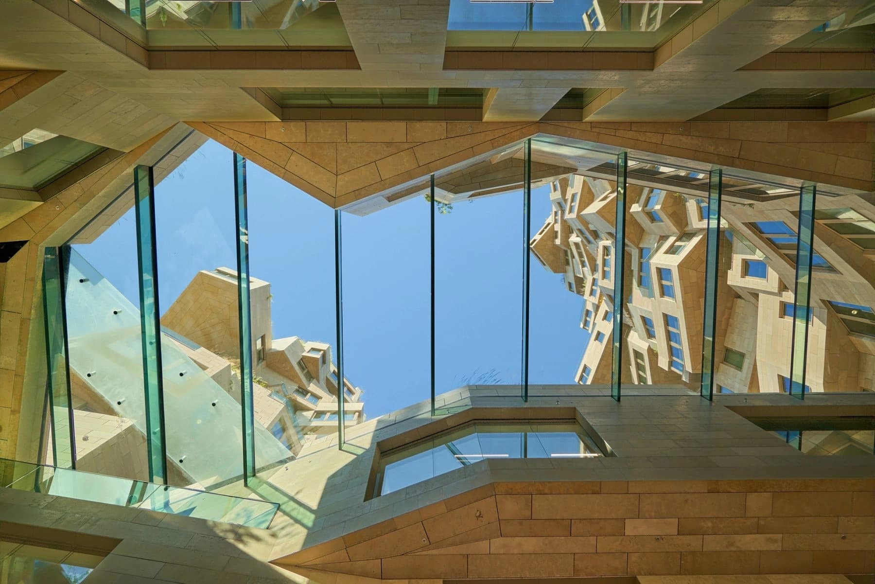 Architectural look-up shot of glass and stone in Amsterdam, used as editorial visual for the studio